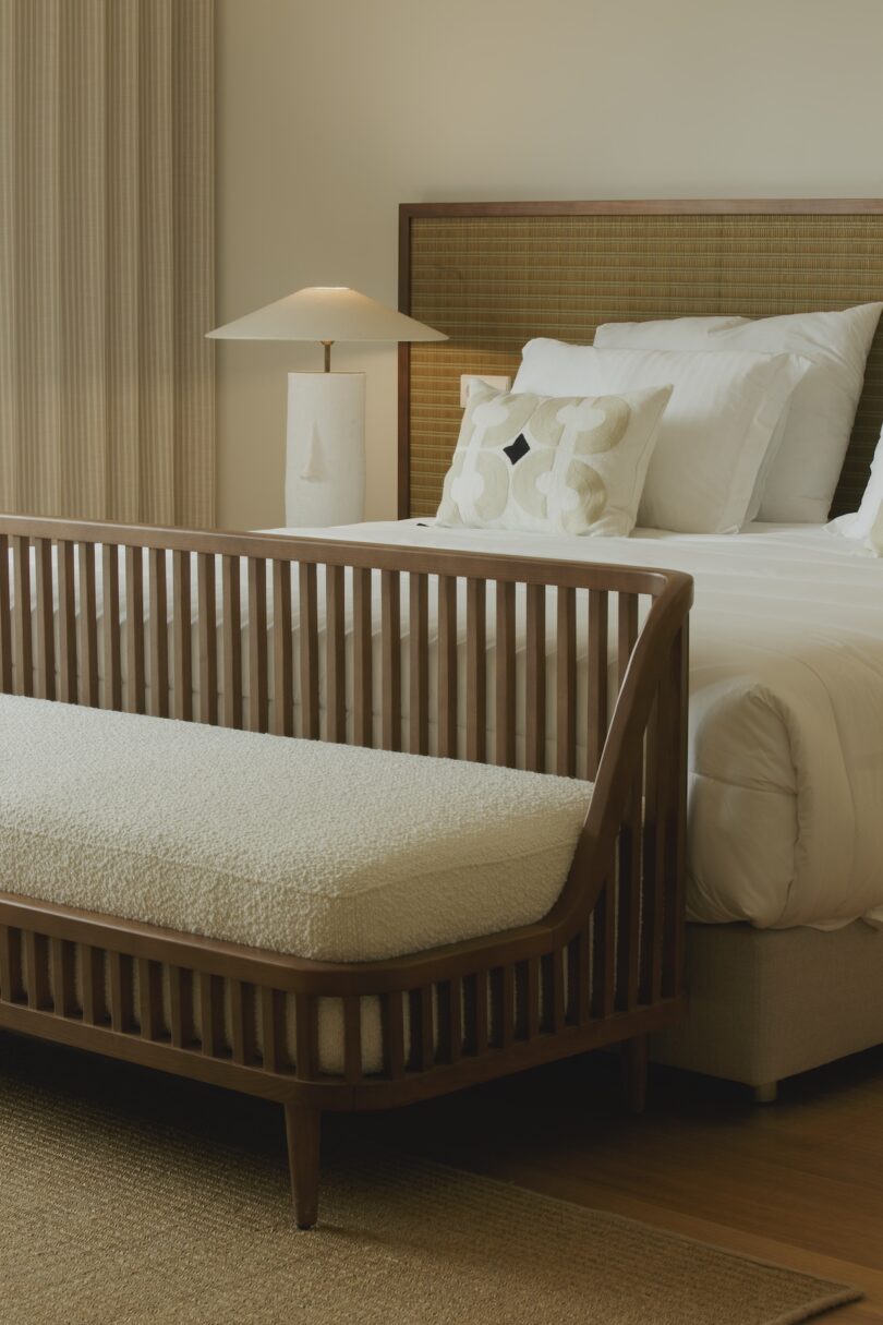 Bedroom featuring a wooden bed with a cozy white duvet, a modern bedside lamp, and a textured headboard, creating a serene and inviting atmosphere